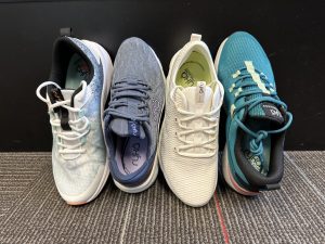 Four pairs of running shoes are lined up on a floor.